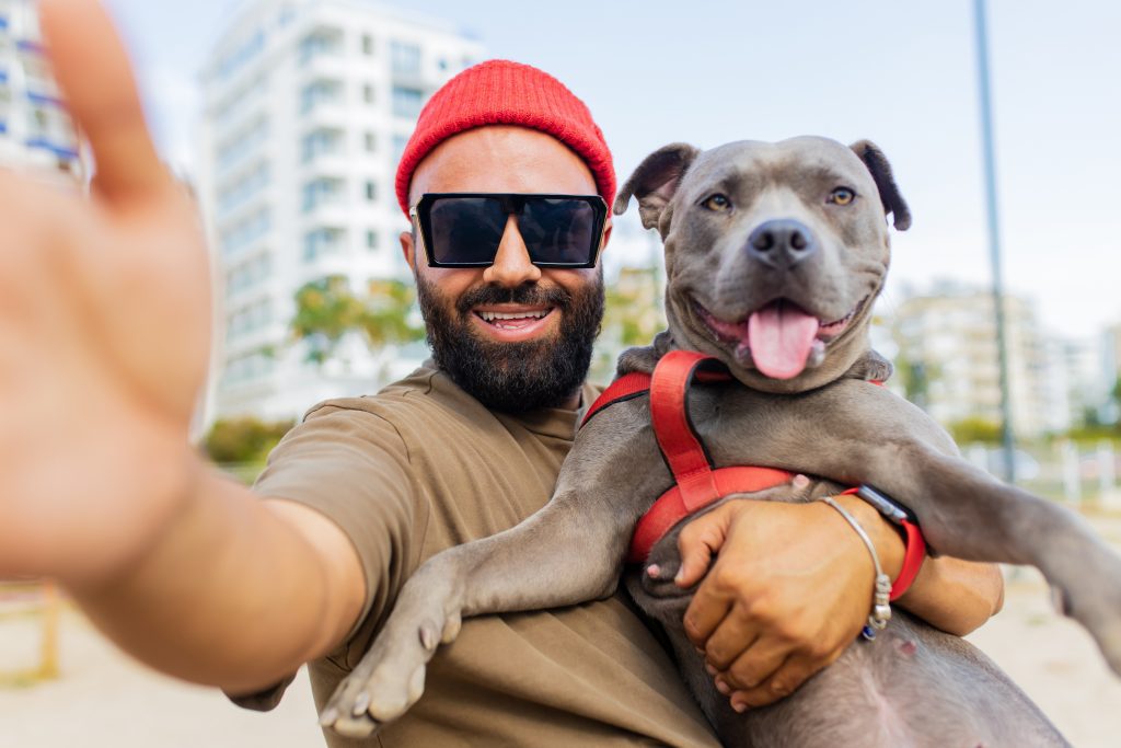 portrait of happy man in red hat and sunglasses with his dog